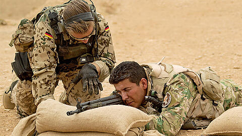 Ein Bundeswehrsoldat weist einen kurdischen Peschmerga in die Handhabung des G3-Sturmgewehrs in Erbil ein.