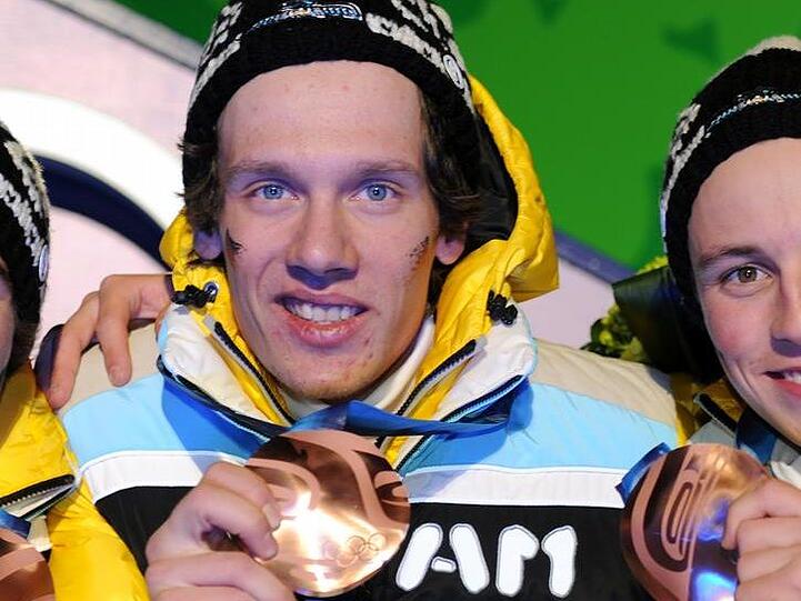 Tino Edelmann freut sich mit seinem Team über die Bronzemedaille.
