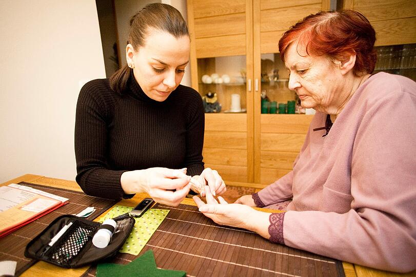 Pflegerin Edina Ahmatovic mit Patientin Ingrid Bunzel bei der Nagelpflege.