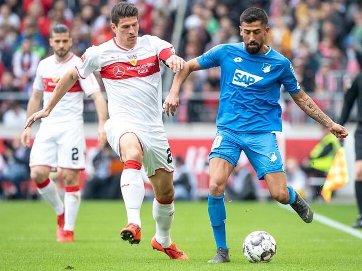 Stuttgarts Mario Gomez (M) im Laufduell mit Hoffenheims Kerem Demirbay. Dahinter sieht Stuttgarts Emiliano Insua zu.