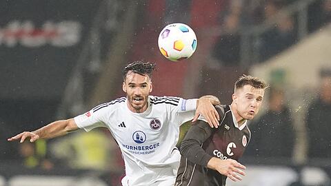 Nürnbergs Iván Márquez (l) und St. Paulis Johannes Eggestein kämpfen um den Ball.