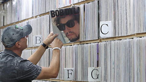 Ein Kunde zieht ein Album des US-amerikanischen Singer-Songwriters Bob Dylan in einem Plattenladen.