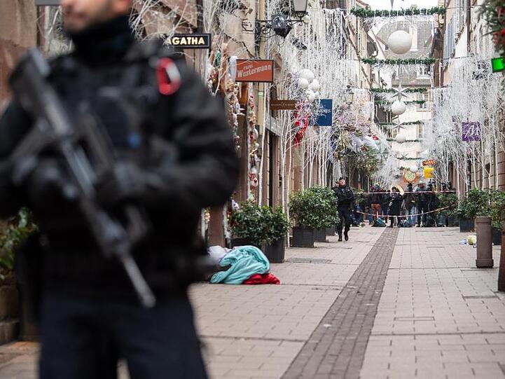Ein Polizist steht nach einem Angriff in der Gegend des Straßburger Weihnachtsmarkts vor einem Tatort.