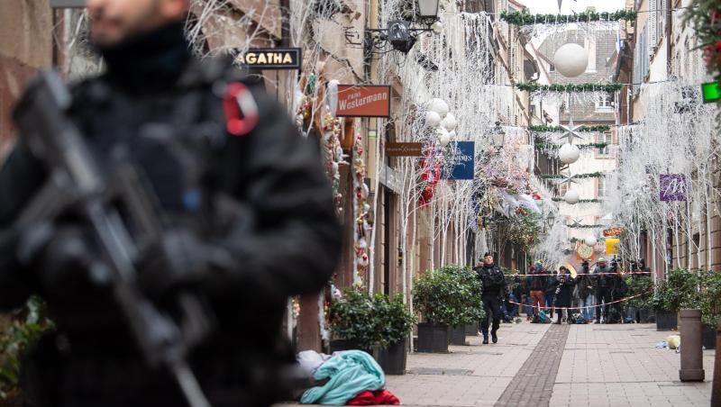 Ein Polizist steht nach einem Angriff in der Gegend des Straßburger Weihnachtsmarkts vor einem Tatort. Ein Polizist steht nach einem Angriff in der Gegend des Straßburger Weihnachtsmarkts vor einem Tatort.
