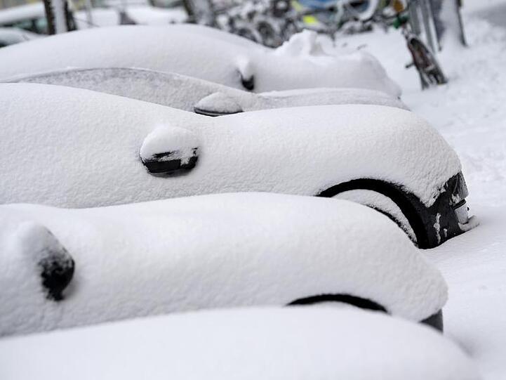 Eingeschneite Autos stehen in einer Straße. Foto: Sven Hoppe