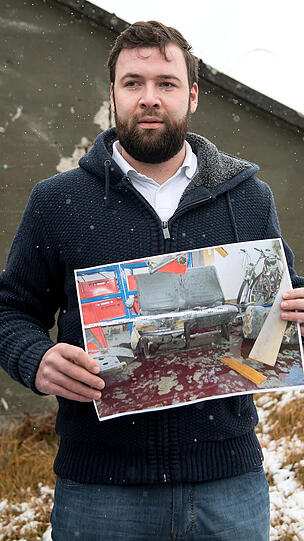 Oliver S. mit einem Foto der völlig zerstörten Garage &ndash; die Wucht der Explosion verletzte ihn lebensgefährlich.