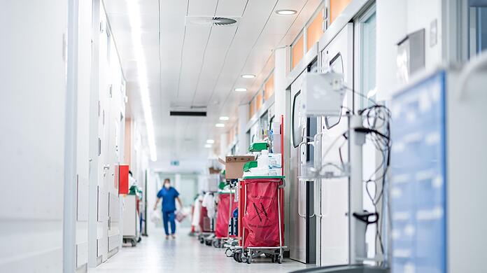 Eine Pflegekraft geht auf einer Intensivstation über den Flur.