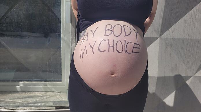 Eine schwangere Frau nimmt an der Pro-Choice-Demo in München Teil.