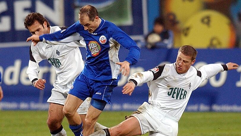 Fußball-Bundesliga FC Hansa Rostock - Borussia Mönchengladbach. (Samstag, 30.11.2002). Die Mönchengladbacher Max Eberl (rechts) und Stephane Stassin (l) versuchen den Rostocker Magnus Arvidsson (M) vom Ball zu trennen.