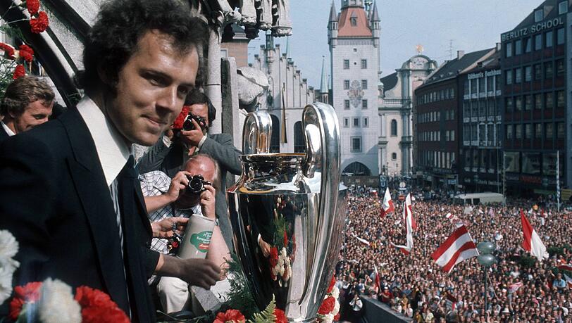 Klar, auch der Rathausbalkon spielt eine gro&szlig;e Rolle in der Historie des FC Bayern. In &uuml;ber 125 Jahren wurden hier schon einige Troph&auml;en in die Luft gehalten &ndash; und Tausende Fans feierten dabei vor dem Rathausbalkon. Wie hier, als Franz Beckenbauer den Sieg des Europapokals der Landesmeister 1974/75 feiert und das Herz der Stadt voll war mit Anh&auml;ngern des Vereins.