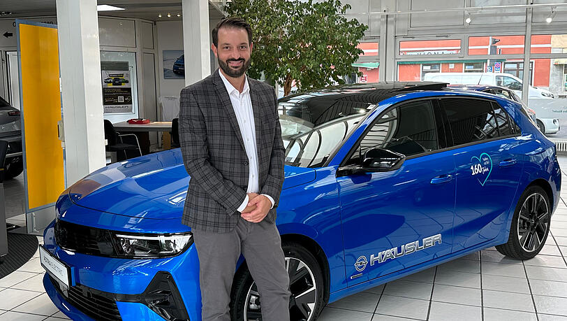 Dominik Steinweg, Teamleiter Opel Verkauf bei Häusler mit dem neuen Opel Astra Electric.