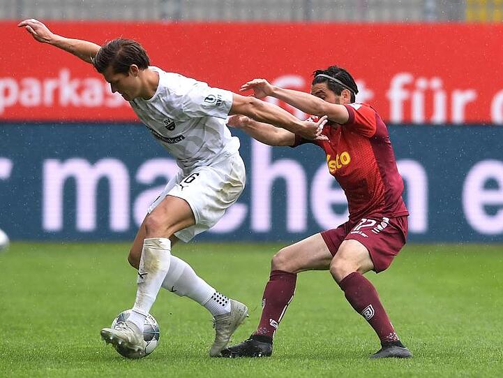 Kevin Behrens (l) vom SV Sandhausen im Zweikampf mit dem Regensburger Oliver Hein.