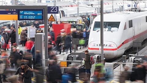 Reisende gehen am Hauptbahnhof über eine Plattform.