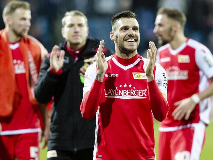Die Spieler vom 1. FC Union Berlin feiern nach dem Sieg in Kiel mit den Fans.