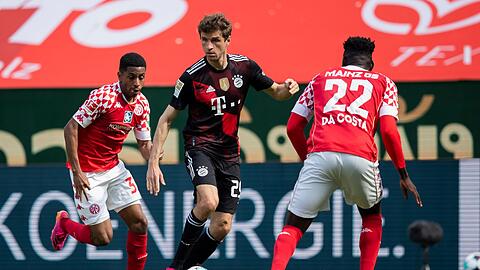 Bayern Münchens Thomas Müller (M) in Aktion gegen die Mainzer Leandro Barreiro Martins (l) Danny Vieira da Costa.