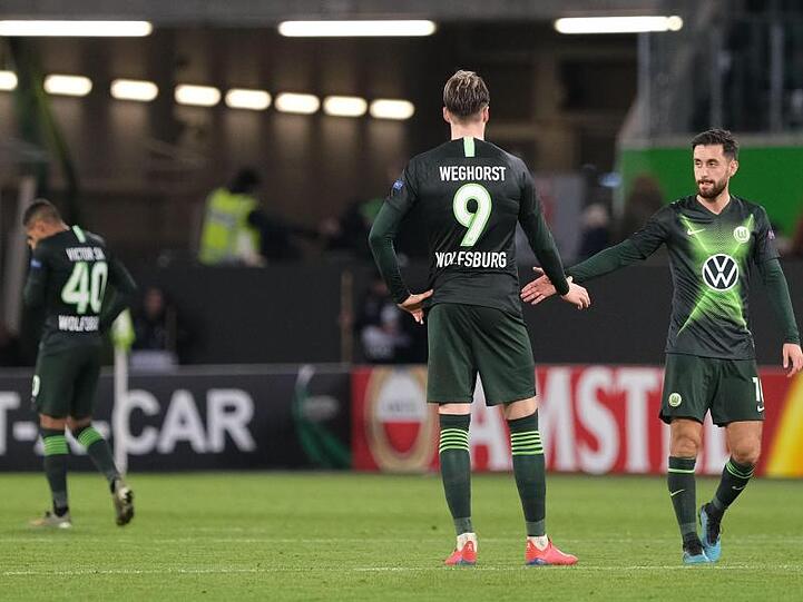 Wolfsburgs Victor Joao (l-r), Wout Weghorst und Yunus Malli stehen nach dem Spiel gegen Gent auf dem Rasen.