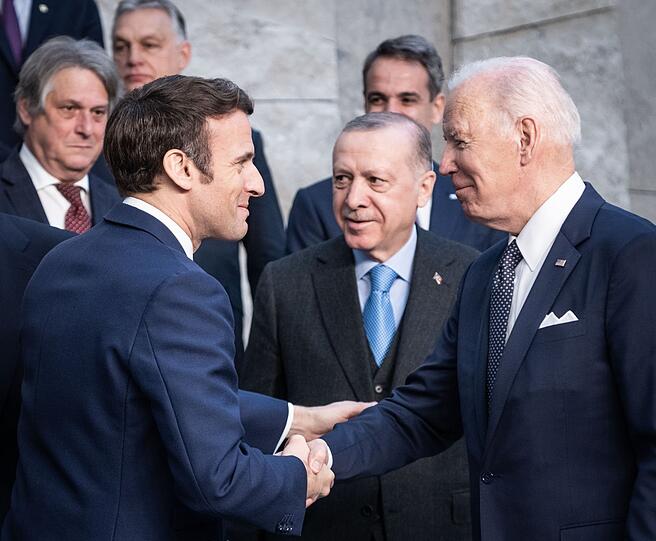Jung und alt in der Spitzenpolitik: Der heute 45-jährige Emmanuel Macron (l.), Präsident von Frankreich, begrüßt Joe Biden (heute 80), Präsident der USA, beim Nato-Sondergipfel im Nato-Hautquartier 2022 in Brüssel. In der Mitte: der türkische Präsident Recep Tayyip Erdogan, heute 69.