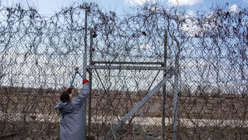 Ein Migrant versucht an der türkisch-griechischen Grenze, mit einer Drahtschere den Zaun durchzuschneiden. Ein Migrant versucht an der türkisch-griechischen Grenze, mit einer Drahtschere den Zaun durchzuschneiden.
