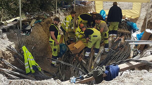Sicherheitskr&auml;fte reparieren im Mai 2021 in M&uuml;nchen nahe des Ostbahnhofs einen Kabelschacht, der zuvor in Brand gesetzt wurde und 20.000 Haushalte und Betriebe vom Stromnetz trennte.