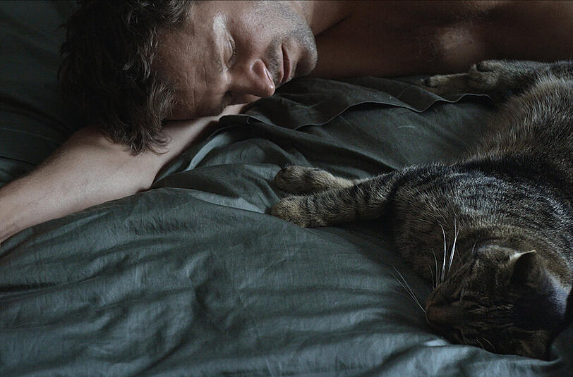Philipp Hochmair als Andreas mit dem Kater.