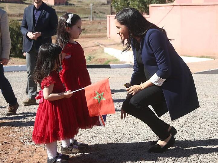Meghan (r), Herzogin von Sussex, unterhält sich mit zwei Mädchen bei ihrem Besuch in Marokko.