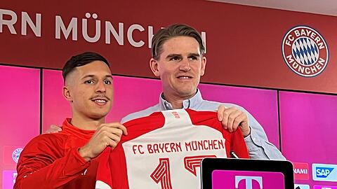 Der Sportdirektor des FC Bayern München, Christoph Freund (r), stellt bei einer Pressekonferenz den spanischen Fußballspieler Bryan Zaragoza vor und übergibt ihm das Trikot mit der Nummer 17.