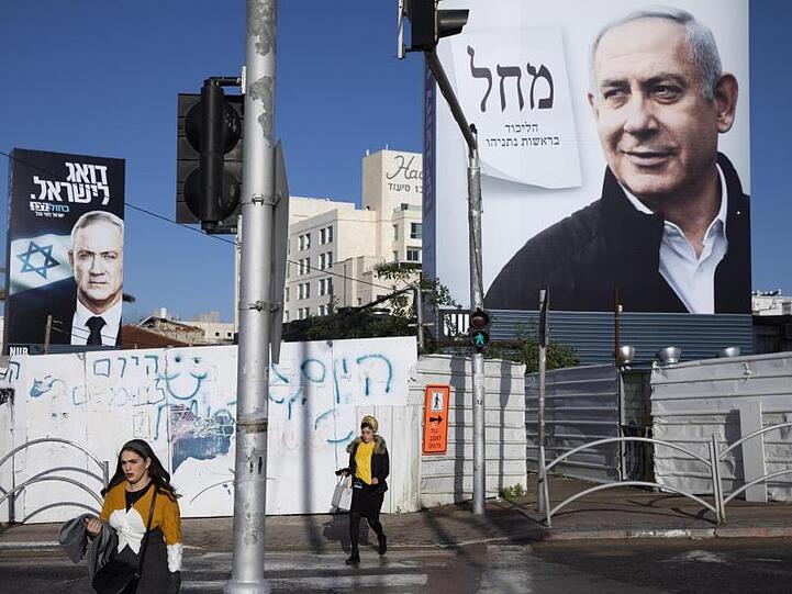 Wahlplakate zeigen den israelischen Ministerpräsidenten Benjamin Netanjahu (r) und den Oppositionspolitiker Benny Gantz (l).
