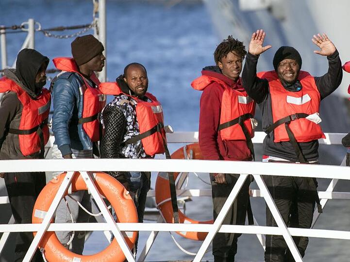 Migranten winken, als sie eins der deutschen Rettungsschiffe im Hafen von Pieta auf Malta verlassen dürfen.