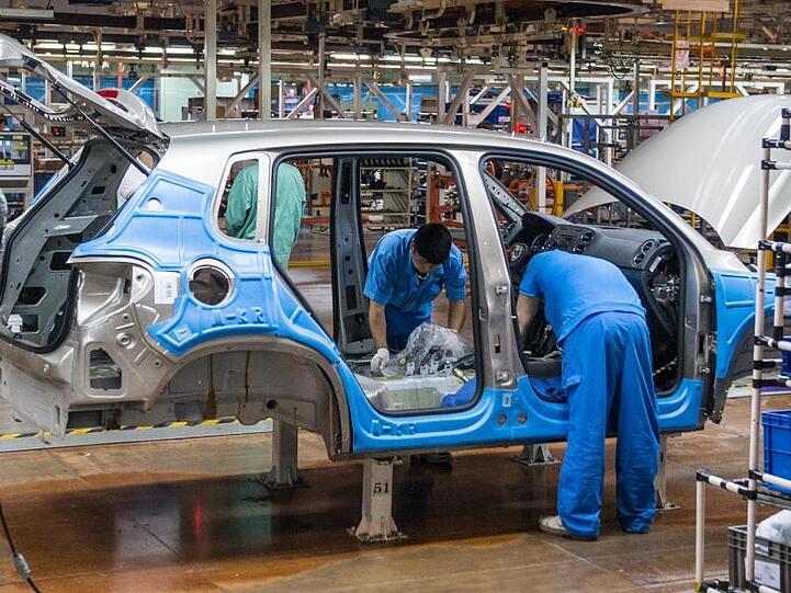Mitarbeiter montieren im Werk der Volkswagen AG in Anting bei Shanghai einen VW Tiguan.