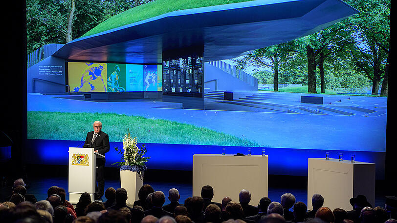 Hinter ihm ist die Gedenkstätte an die Wand projeziert: Bundespräsident Frank-Walter Steinmeier spricht zur Eröffnung in der BMW-Welt.