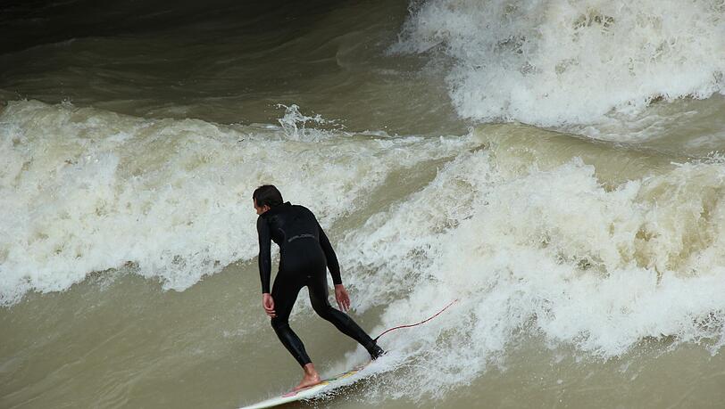 Hochwasser für die einen, perfekte Wellen für die anderen. Waghalsig tummeln sich Sportler in der Isar. Hochwasser für die einen, perfekte Wellen für die anderen. Waghalsig tummeln sich Sportler in der Isar.