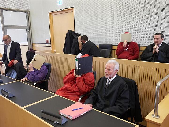 Im Landgericht Limburg verbergen die Angeklagten vor der Urteilsverkündung ihre Gesichter.