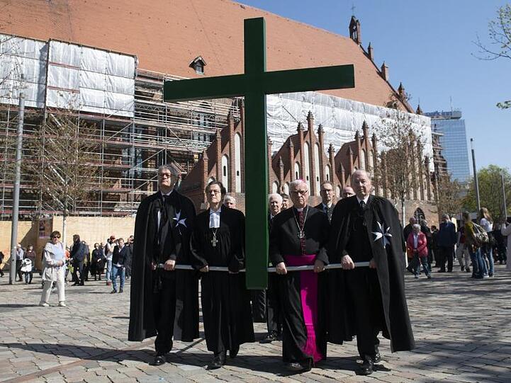 Kirchenvertreter, darunter Markus Dröge (2.v.l.), Bischof der Evangelischen Kirche Berlin-Brandenburg-schlesische Oberlausitz, und Heiner Koch (2.v.r.), Erzbischof von Berlin, tragen bei der ökumenischen Karfreitagsprozession in der Bundeshauptstadt ein Kreuz.