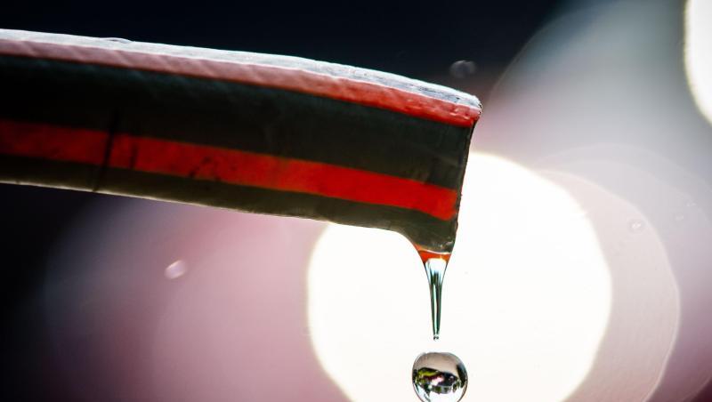 Wasser tropft aus einem Schlauch.