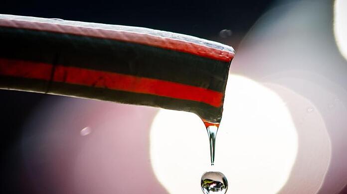 Wasser tropft aus einem Schlauch.