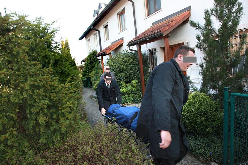 Bestatter bringen die Leiche der Frau aus dem Haus, in dem die Eheleute 18 Jahre zusammen gelebt hatten.
