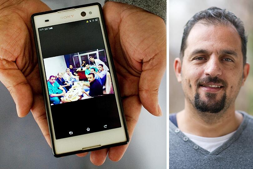 Hamza (42) aus Damaskus in Syrien zeigt ein Foto von einer Feier mit Krankenhaus-Mitarbeitern.