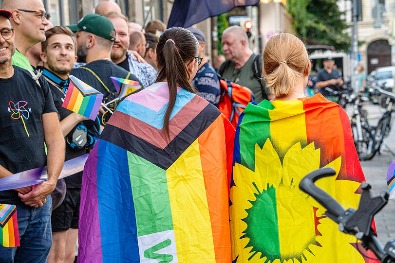 Queere Demo mit Menschenkette: Teilnehmerinnen mit Regenbogenfahnen