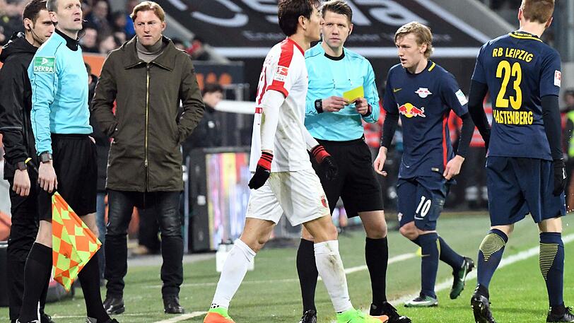 Schiedsrichter Patrick Ittrich zeigt Augsburgs Dong-Won Ji die gelbe Karte.