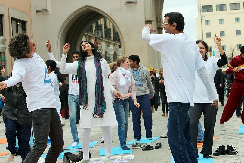 Hopsen und Dehnen in der Fußgängerzone: Am Stachus haben sich Yoga-Fans zu einem Flashmob unter freiem Himmel verabredet. Die Bilder.
