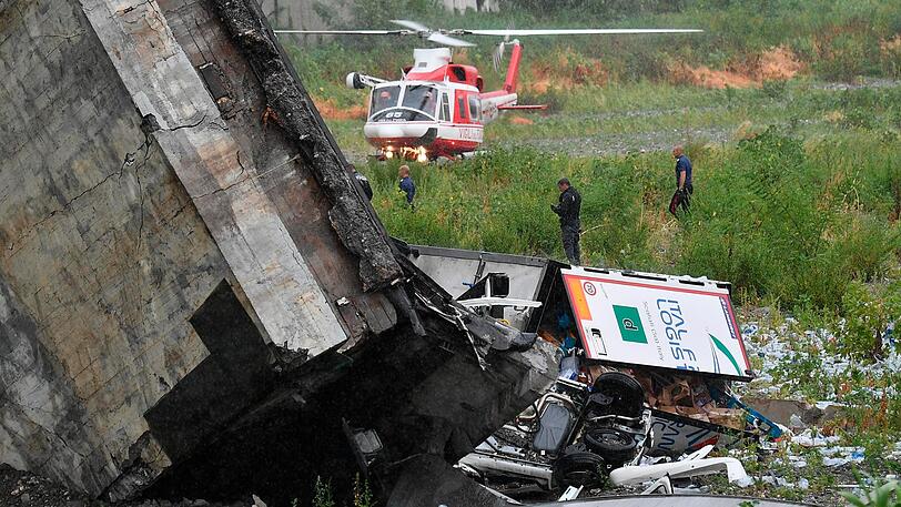 Rettungsarbeiten unter den Trümmern der eingestürzten Morandi Autobahnbrücke.