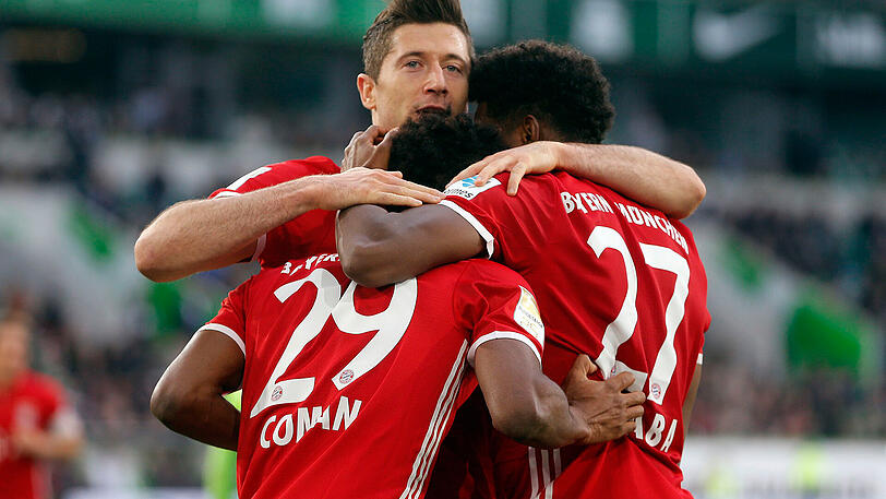 Robert Lewandowski bricht seine Torhemmungen und trifft gegen Wolfsburg doppelt. Das feiert er mit Kingsley Coman und David Alaba.
