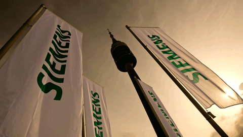 Dunkle Wolken über wehenden Siemens-Flaggen in München - Wie viele Stellen fallen an den bayerischen Standorten des Konzerns weg?