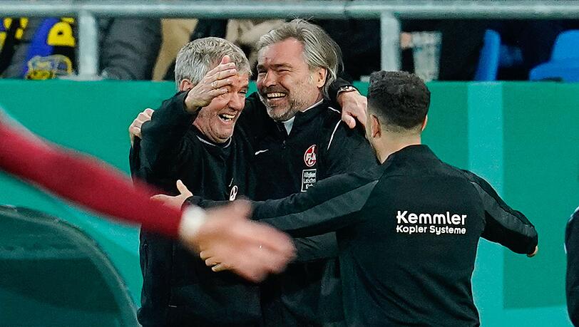 Kaiserslauterns Trainer Friedhelm Funkel (l) und Co-Trainer Matthias Lust (M) feiern nach dem Schlusspfiff.