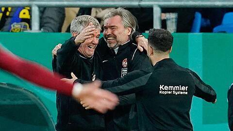 Kaiserslauterns Trainer Friedhelm Funkel (l) und Co-Trainer Matthias Lust (M) feiern nach dem Schlusspfiff.
