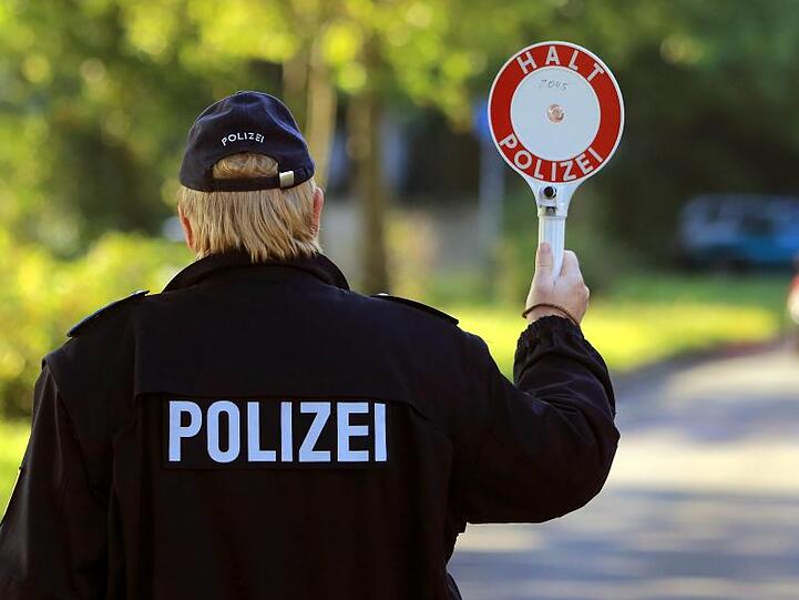 Erwischt: Ein Polizist winkt ein Auto an den Fahrbahnrand.