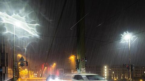 Autos fahren bei Starkregen und Gewitter durch Düsseldorf.