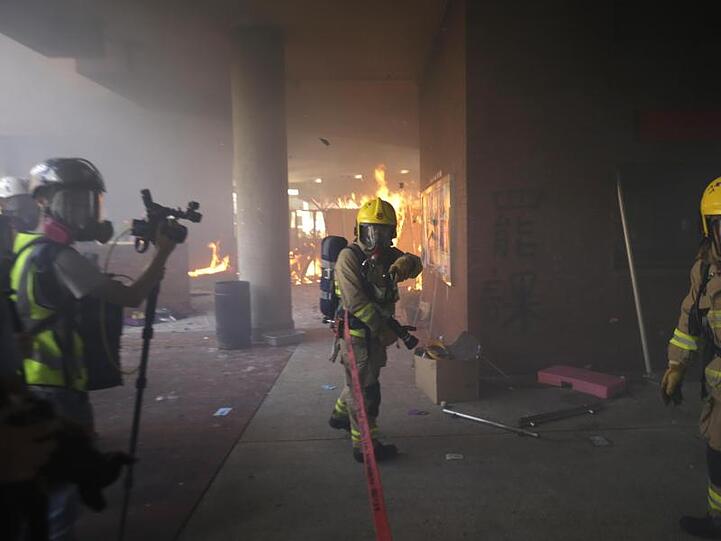Feuerwehrleute versuchen ein von Demonstranten ausgelöstes Feuer in der Polytechnischen Universität zu löschen.
