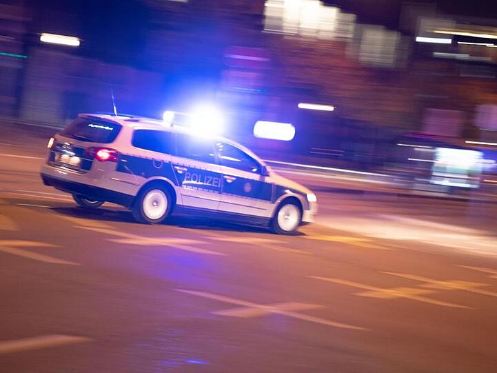 Ein Polizeiauto fährt unter Einsatz von Blaulicht und Sirene eine Straße entlang. Foto: Lino Mirgeler/Archiv