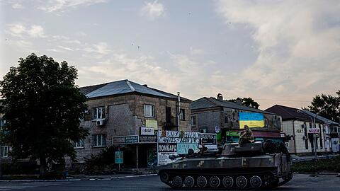 Ukrainische Soldaten fahren auf einem Panzer durch eine Straße im ostukrainischen Pokrovsk.